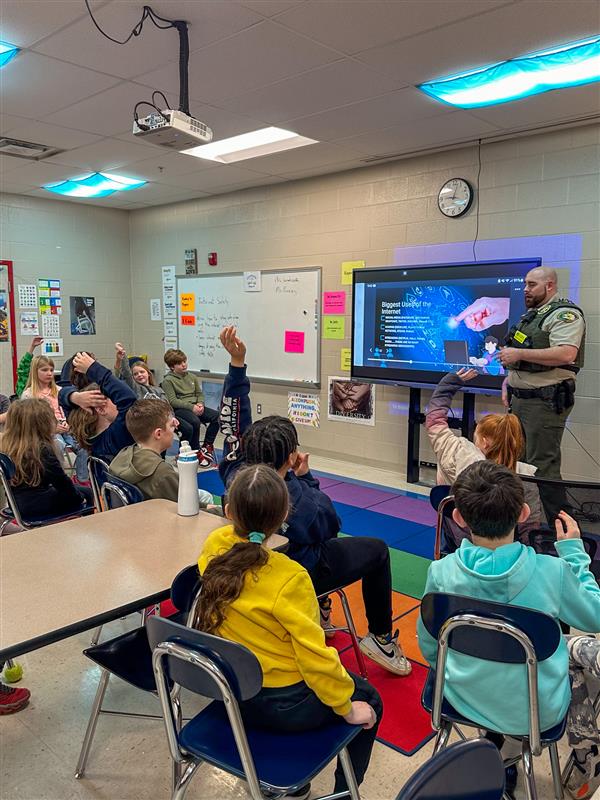 police officer talking to class of students